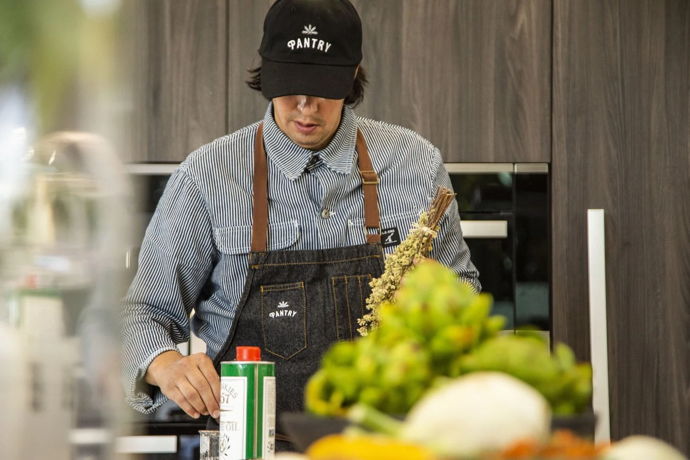 Chef Michael Magliano in the kitchen wearing an apron and selecting ingredients