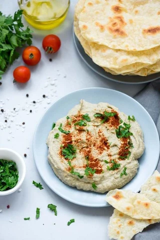a shallow bowl of whipped eggplant dip topped with deep red chili powder
